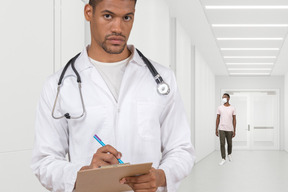 A man in a white lab coat writing on a clipboard