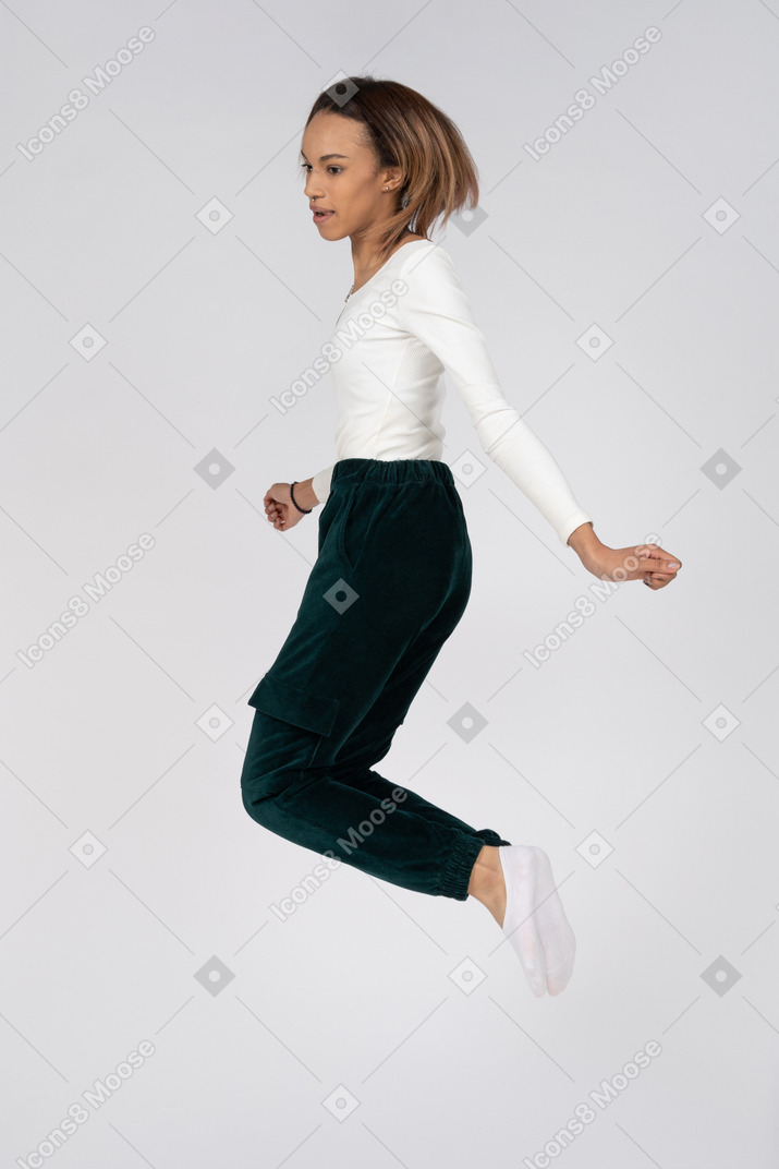 カジュアルな服を着てジャンプする女性