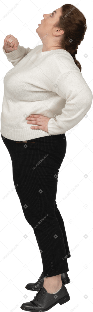 Vista lateral de uma mulher gorda em roupas casuais olhando para cima