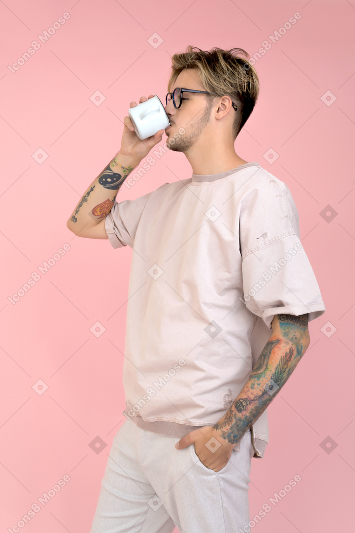 Молодой человек пьет кофе