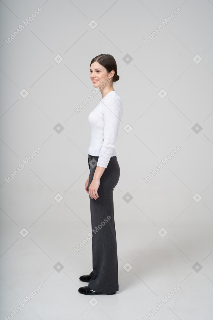 Side view of a smiling woman in business casual clothes looking aside