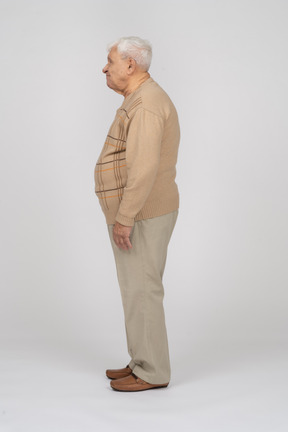 Old man in casual clothes standing in profile