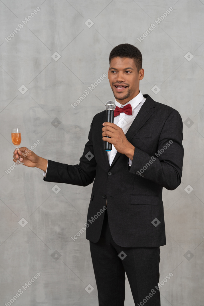 Man with mic and flute glass proposing a toast