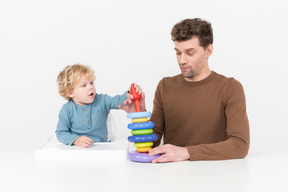 Father and son assembling a stacking toy