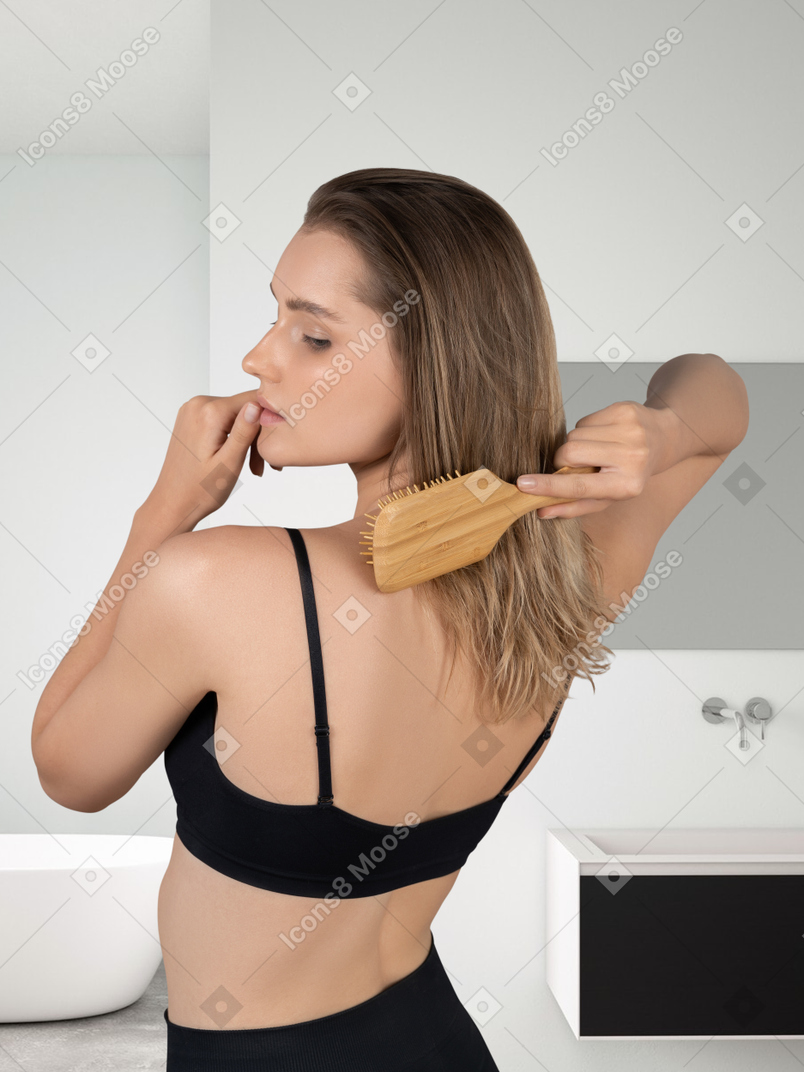 Mujer cepillándose el pelo en el baño