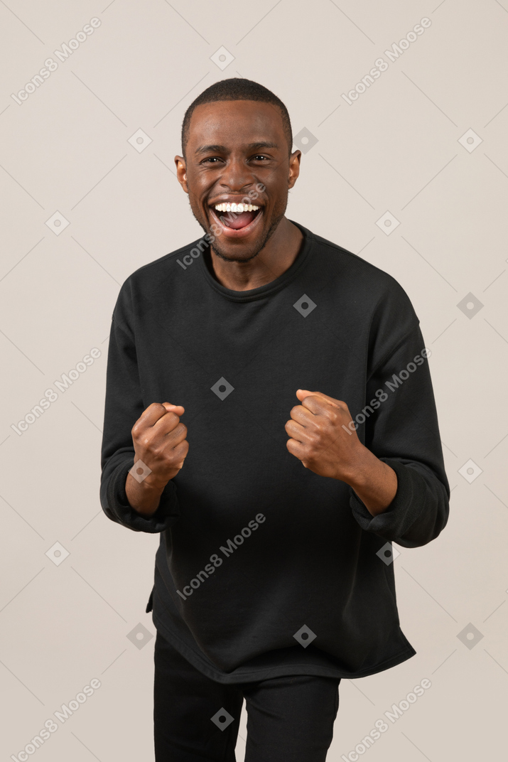 Young man with clenched fists cheering
