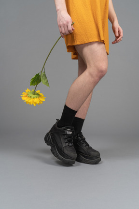 Cropped photo of a person in orange dress holding a sunflower