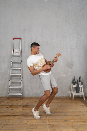 Three-quarter view of a man rocking out on ukulele