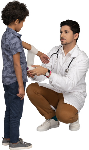 Doctor bandaging hand of a boy