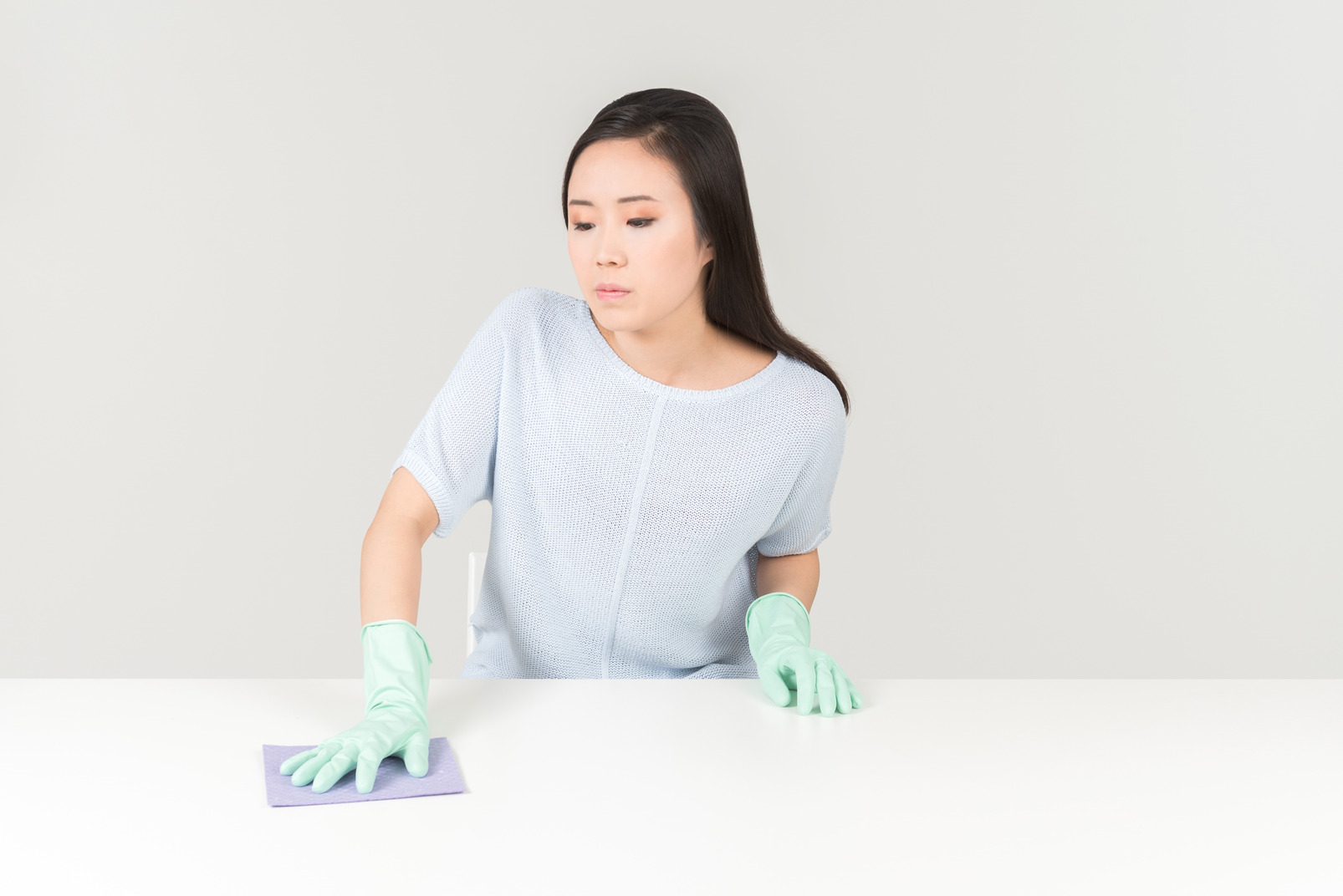 Young asian woman cleaning table surface
