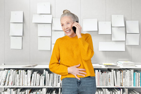 Donna anziana allegra che parla al telefono