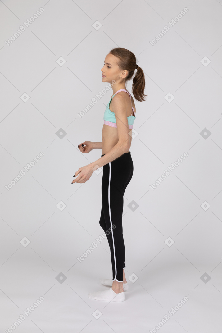 Side view of a teen girl in sportswear raising hand and arguing