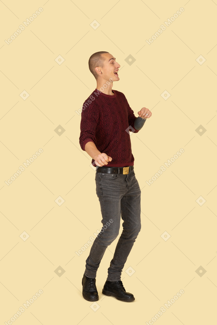 Vista di tre quarti di un giovane uomo che ride in pullover rosso