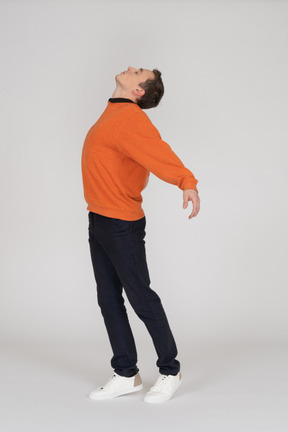 Jeune homme en sweat-shirt orange sautant