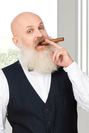 A bald man with a cigar in his mouth