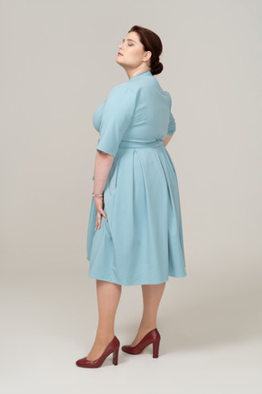 Woman in blue dress standing in profile