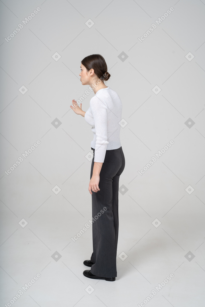 黒のズボンと白のブラウスのジェスチャーで女性の側面図