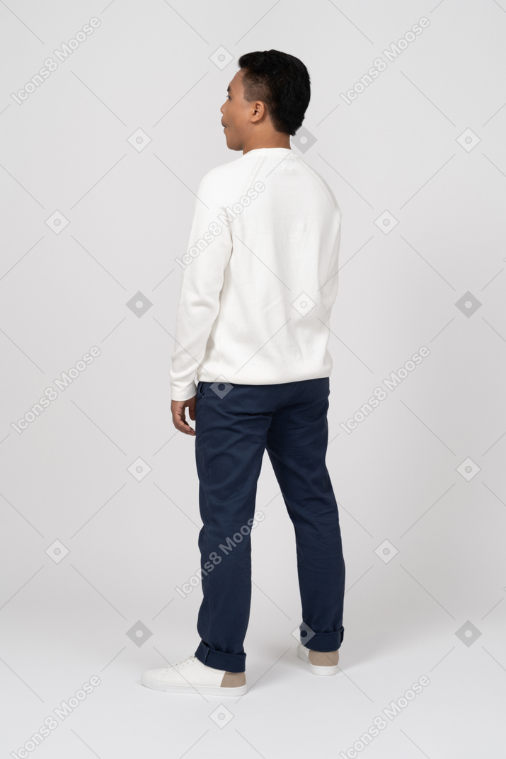 Back view of man wearing white sweater and jeans