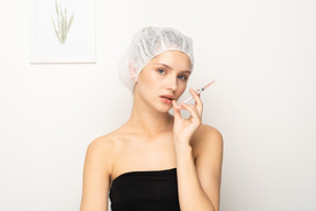 Woman with syringe looking at camera