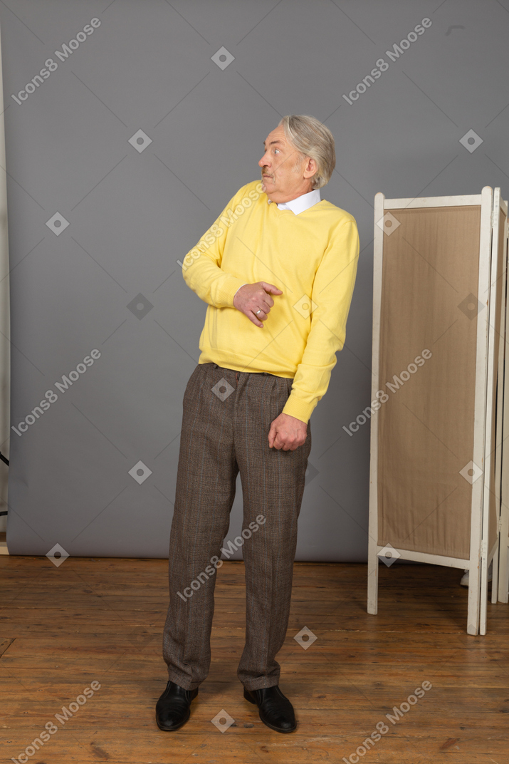 Vista de tres cuartos de un anciano asustado reclinado hacia atrás
