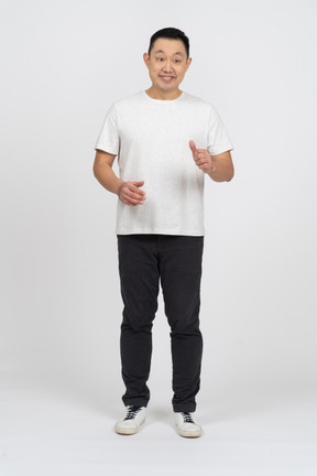 Vista frontal de un hombre con ropa informal que muestra el pulgar hacia arriba