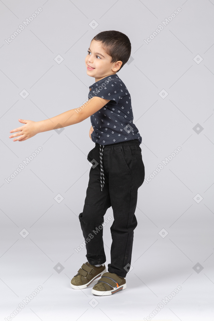 Vista lateral de un chico lindo dando una mano para agitar