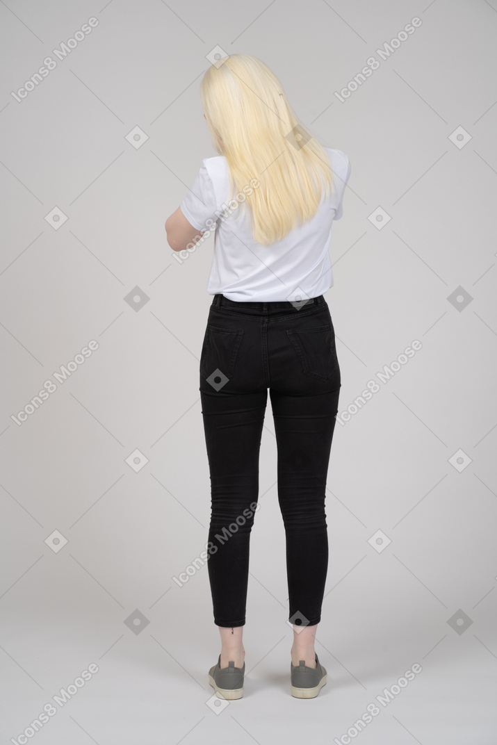 Vista traseira de uma mulher de cabelos compridos em pé