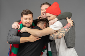 Close-up of four male football fans celebrating the victory & hugging