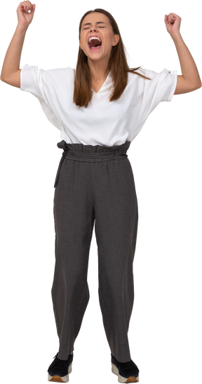 Front view of a screaming young lady in office clothing raising hands