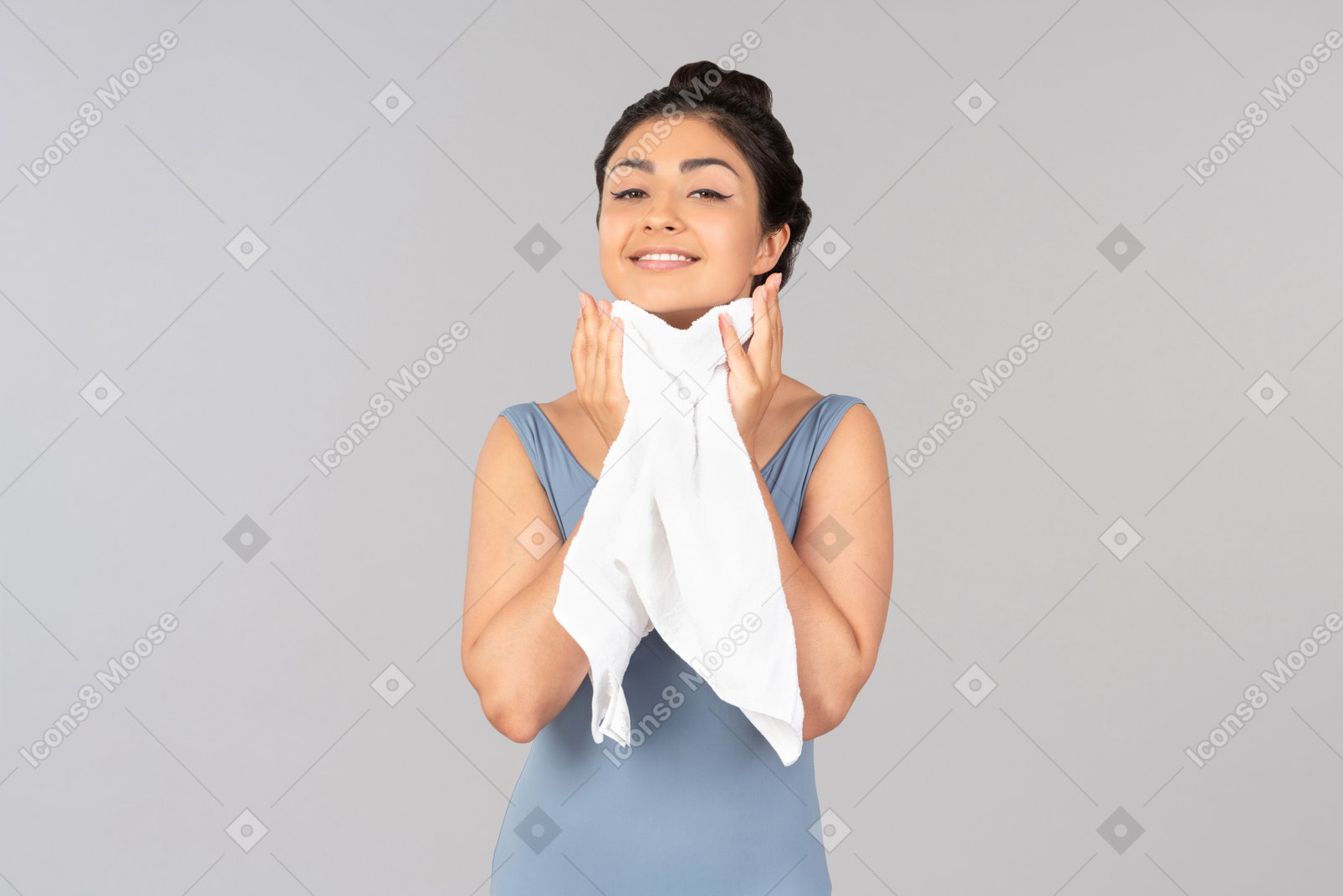 Молодая индийская женщина с закрытыми глазами сушит лицо полотенцем