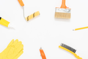 Un ensemble d'outils de peinture disposés en cercle sur le fond blanc