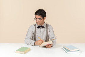 Professor sentado em sua mesa com livros