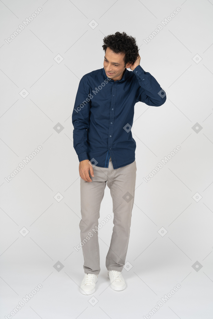 Front view of a man in casual clothes scratching head