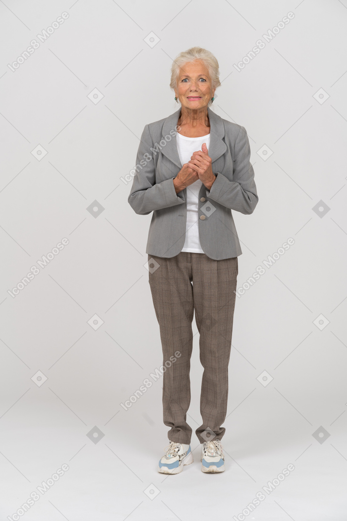 Vista frontal de una anciana feliz en traje mirando a la cámara