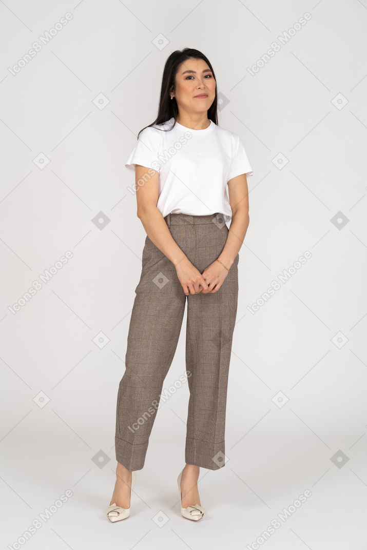 Vista frontal de una joven confundida en pantalones y camiseta tomados de la mano juntos