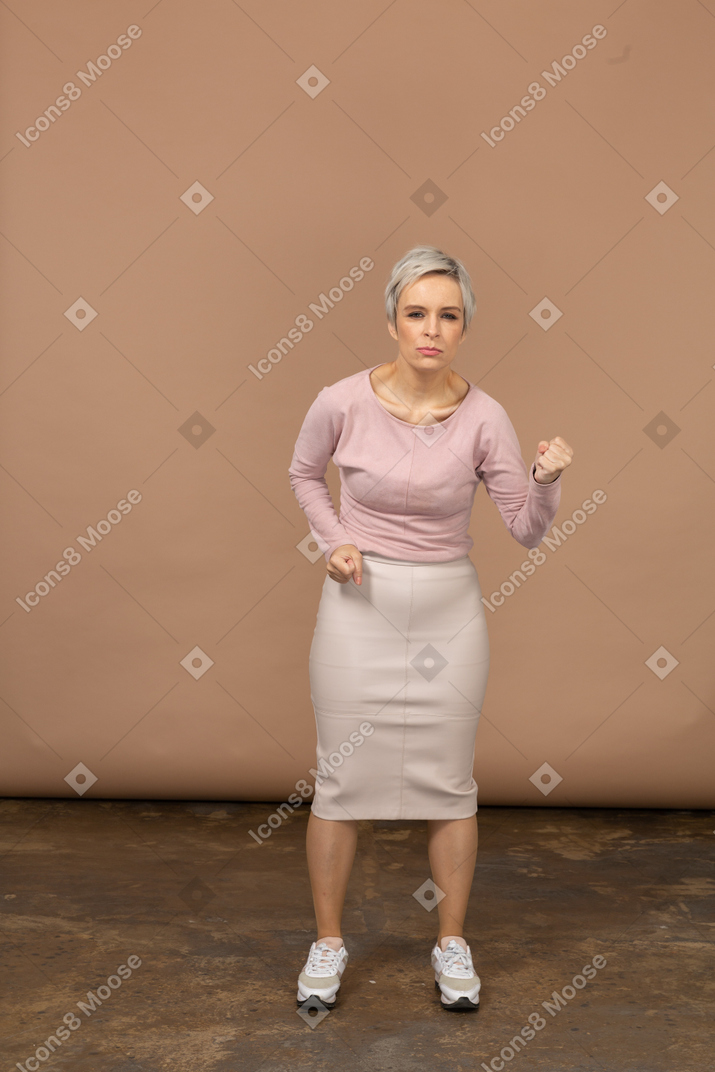 Vista frontal de uma mulher com raiva em roupas casuais, mostrando o punho