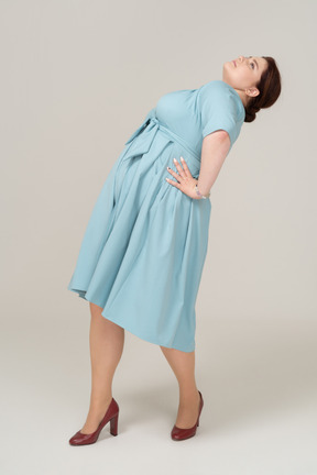 Side view of a woman in blue dress leaning back