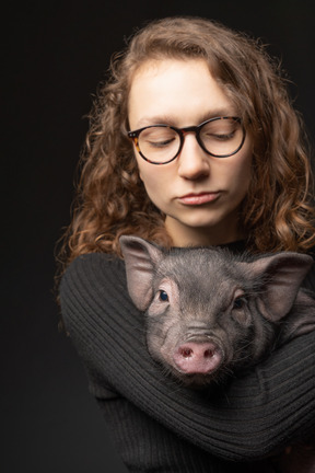 Hermosa chica con cerdo en miniatura