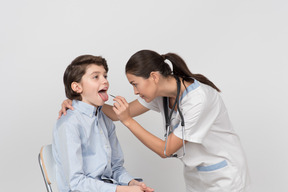 Femme médecin examine la bouche du patient