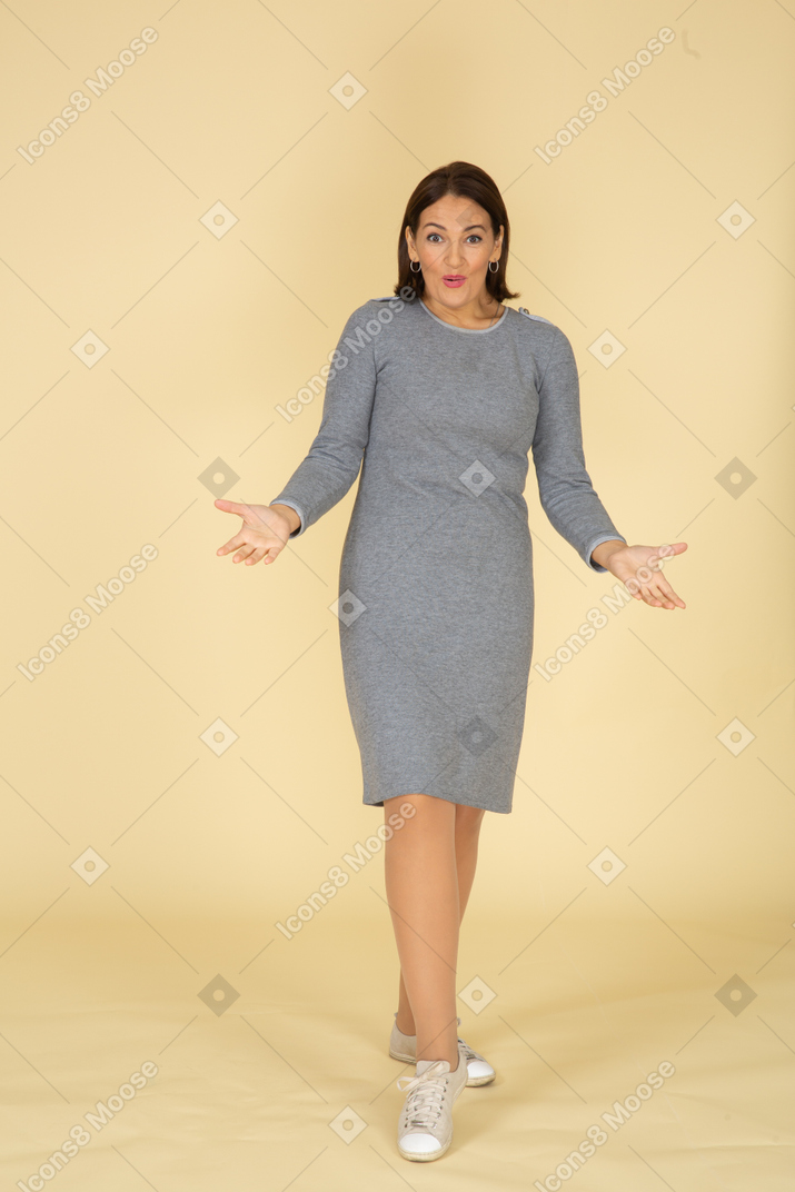 Front view of a woman in grey dress gesturing