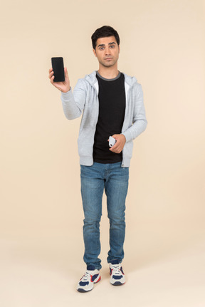 Young caucasian man holding two smartphones