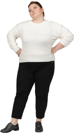 Angry plump woman in casual clothes standing with hands on hips