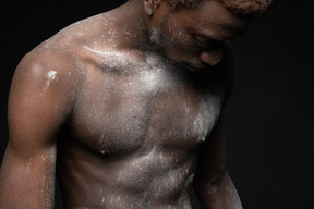 Sensual shot of a young male with his torso covered with flour