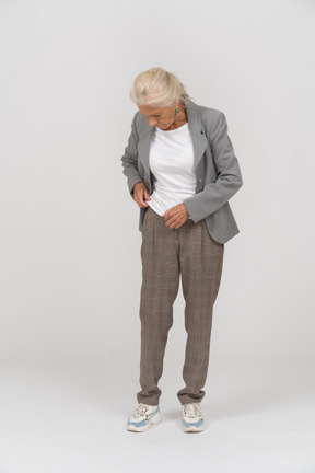 Vista frontal de uma senhora idosa de terno olhando para baixo