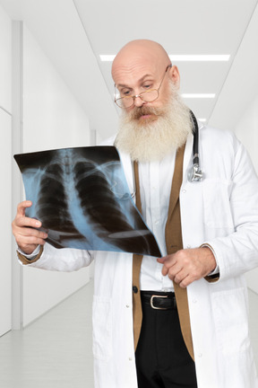 Männlicher arzt, der ein röntgenbild betrachtet
