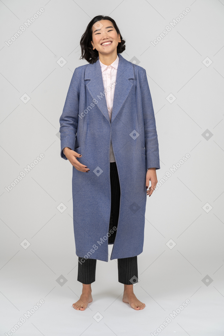 Mujer con abrigo azul sonriendo alegremente