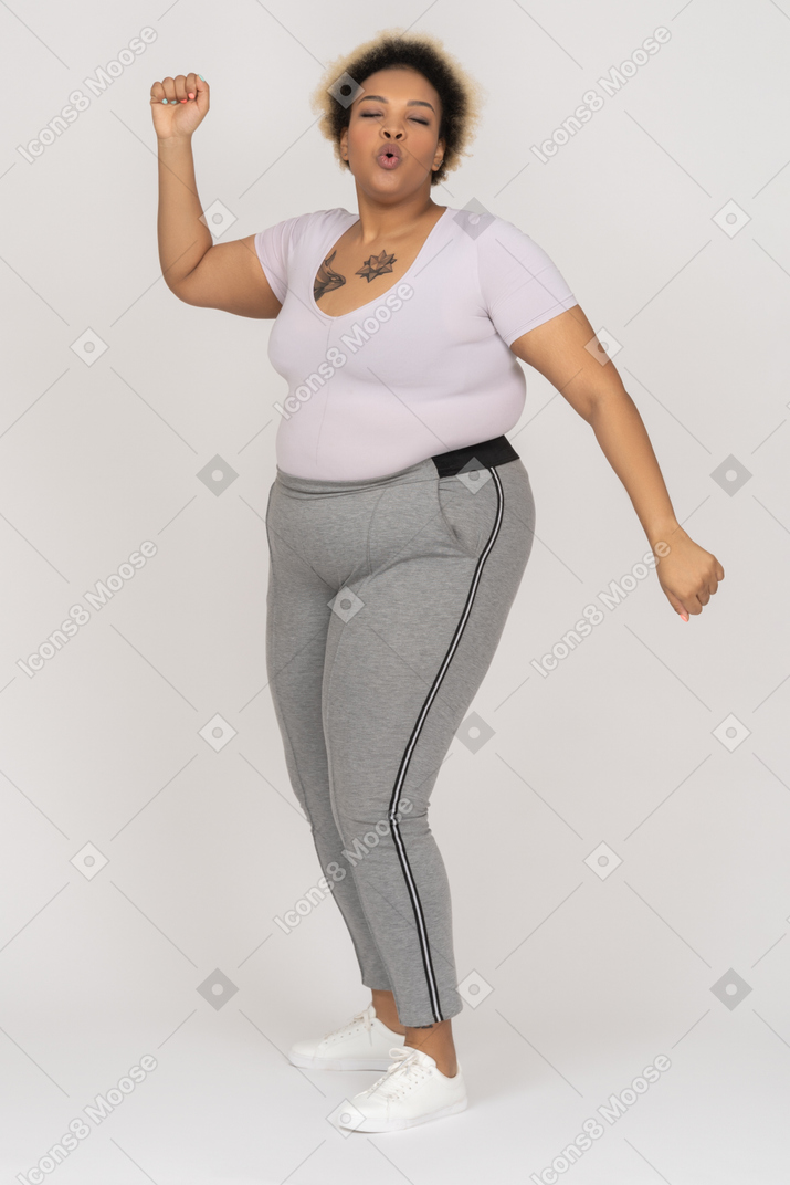 Delighted african-american female dancing alone