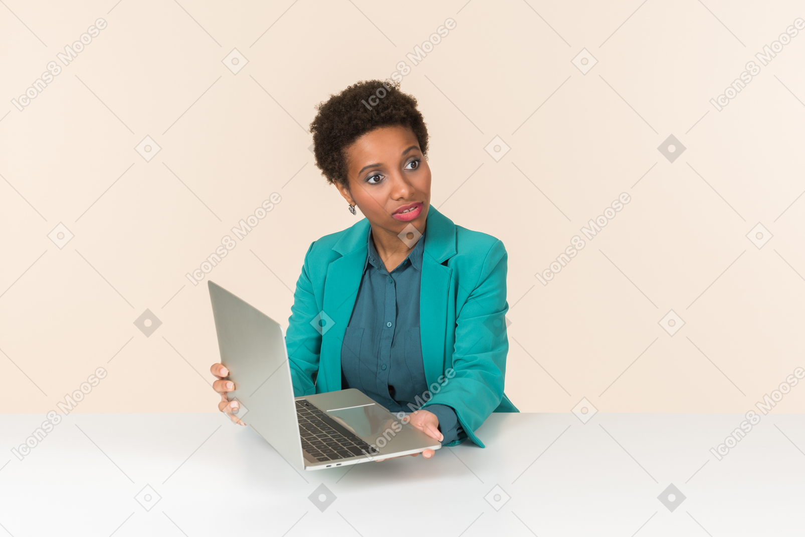 Jeune employée de bureau pointant vers l'ordinateur portable