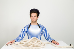 Sailor sitting at the table with rope on it