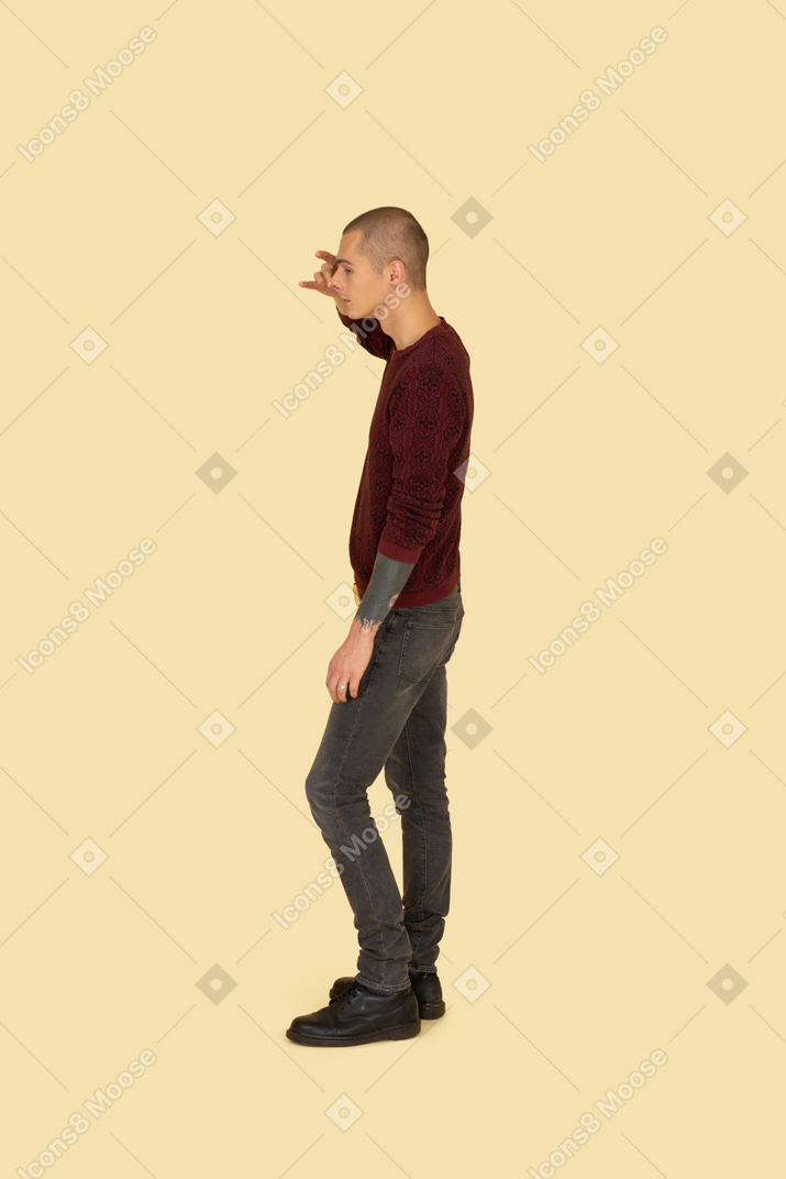 Side view of a funny young man touching his nose